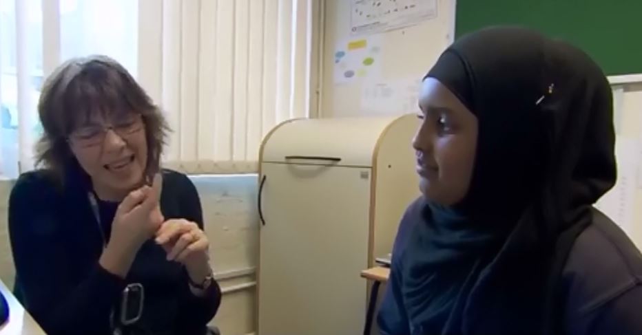 Teacher signing to a HI student